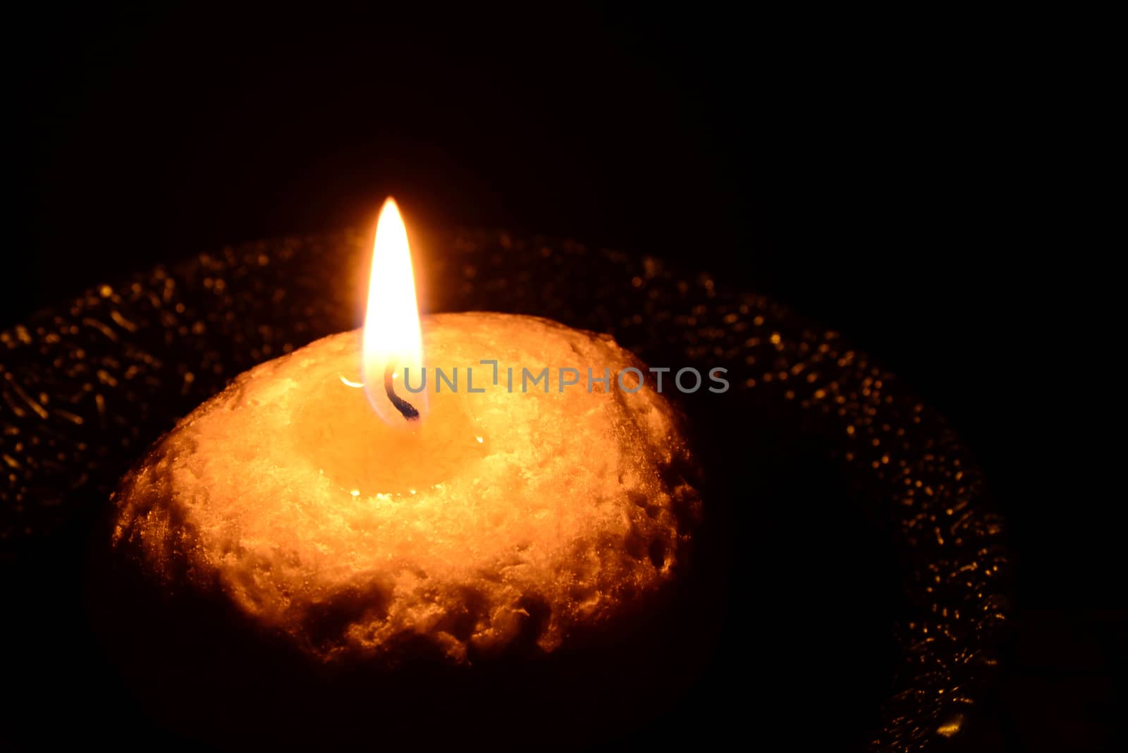 White candle on a plate burning on a black background by dk_photos
