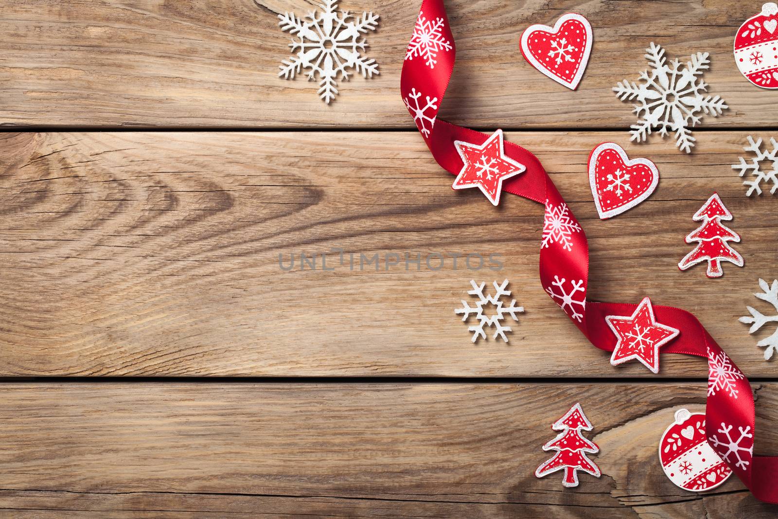 Christmas background with snowflakes and red decoration on wooden table. Copy space. Top view