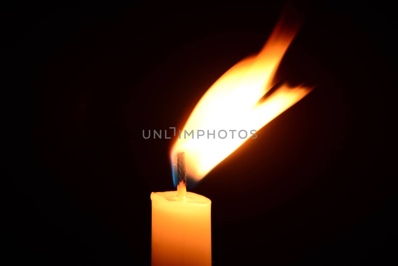 White candle burning on a black background by dk_photos