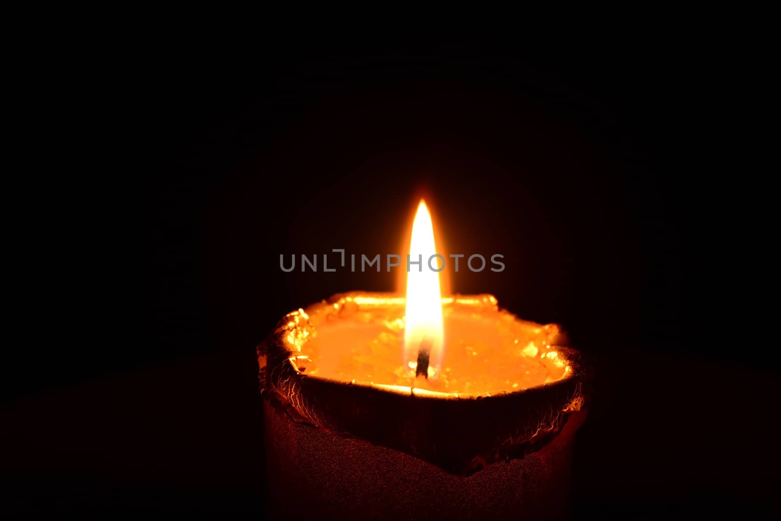 Golden candle burning on a black background by dk_photos
