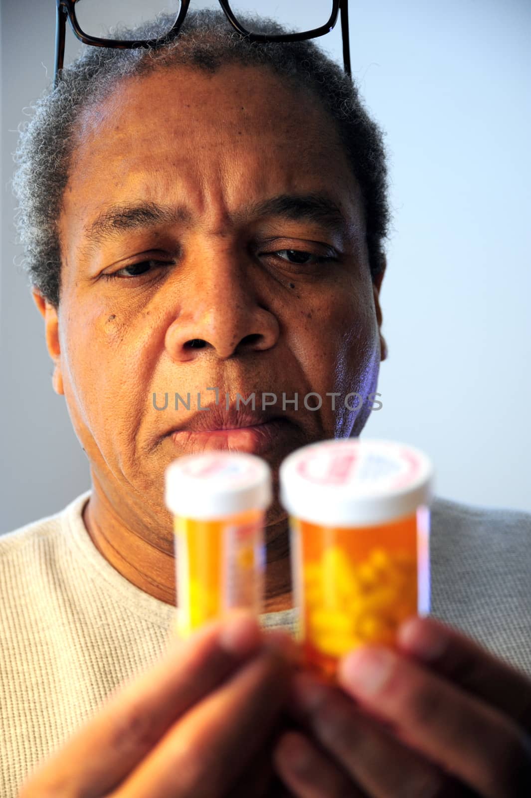 Black man taking medicine for high blood pressure.