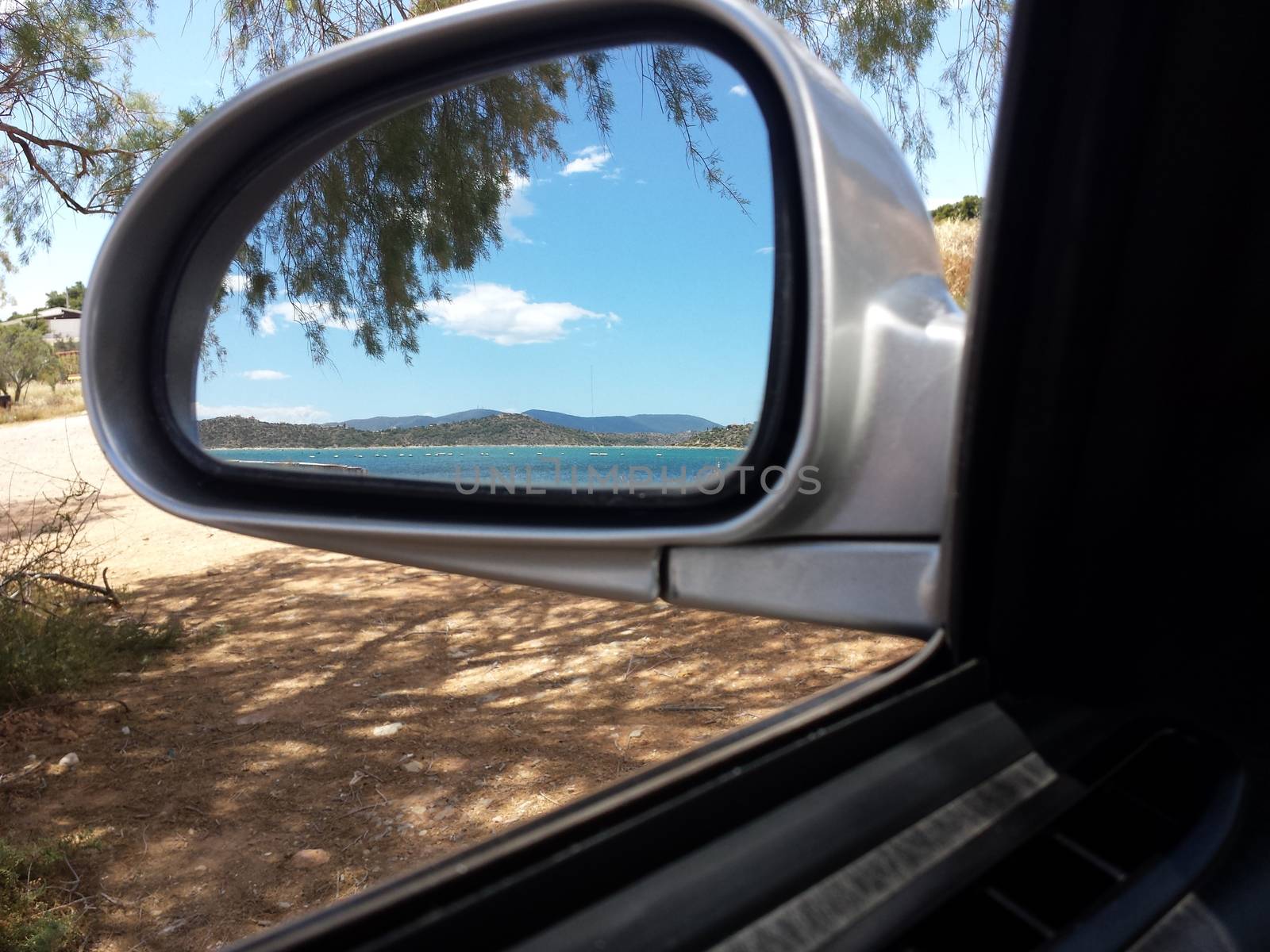 A view of the crystal-clear waters of a Greek Beach, through the car's mirror.

Picture taken on May 30, 2014.