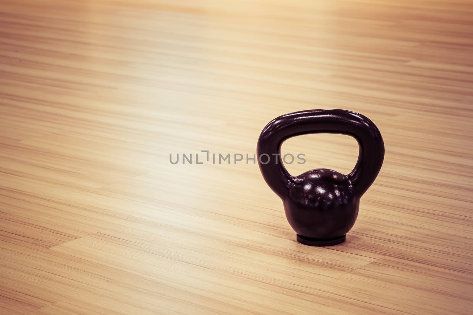 black iron kettlebell weight on wooden floor