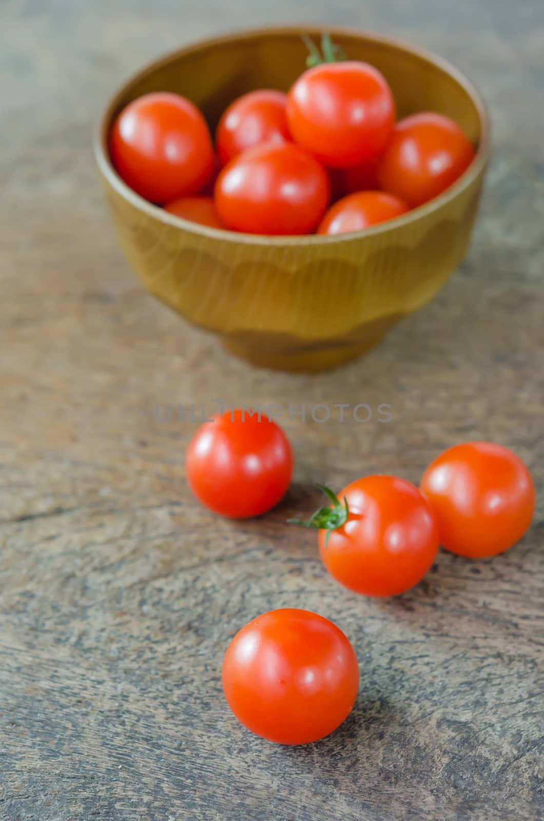 Red cherry tomatoes  on a textured  wooden background