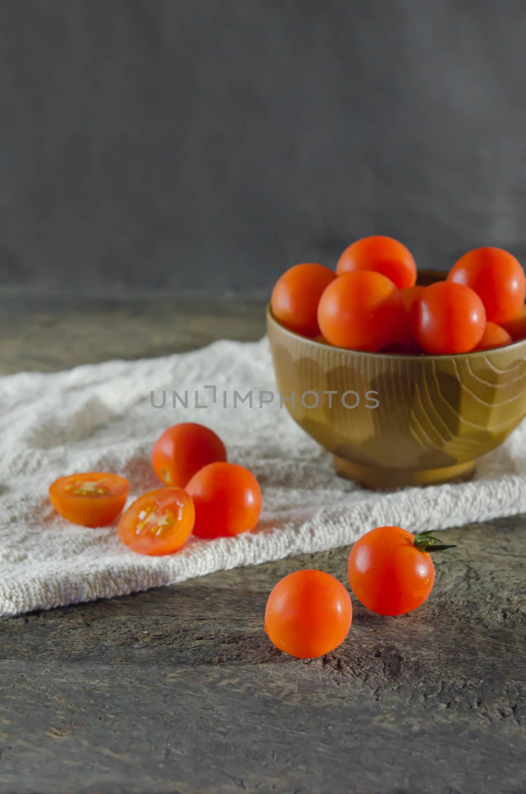 Red cherry tomatoes  on a textured  wooden background