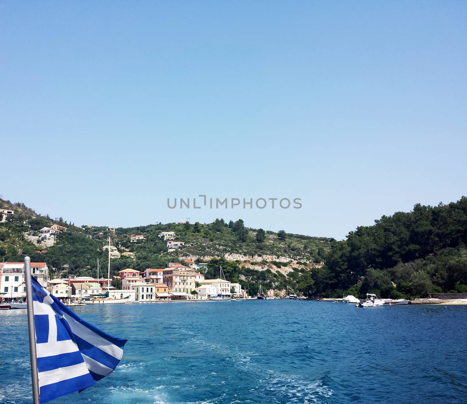 Leaving the port on a boat with a Greek Flag, Gaios Port, Paxos Island, Greece.

Picture taken on July 5, 2014.