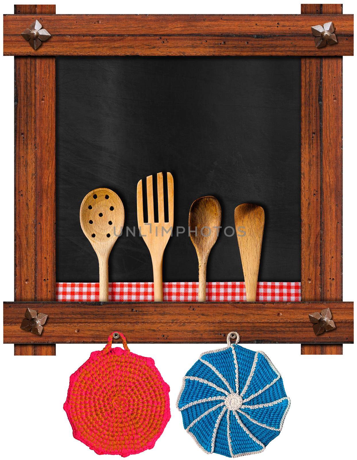 Empty blackboard with wooden frame and ancient nails, four wooden kitchen utensils, two wool pot holders, red and white checkered tablecloth isolated on white background
