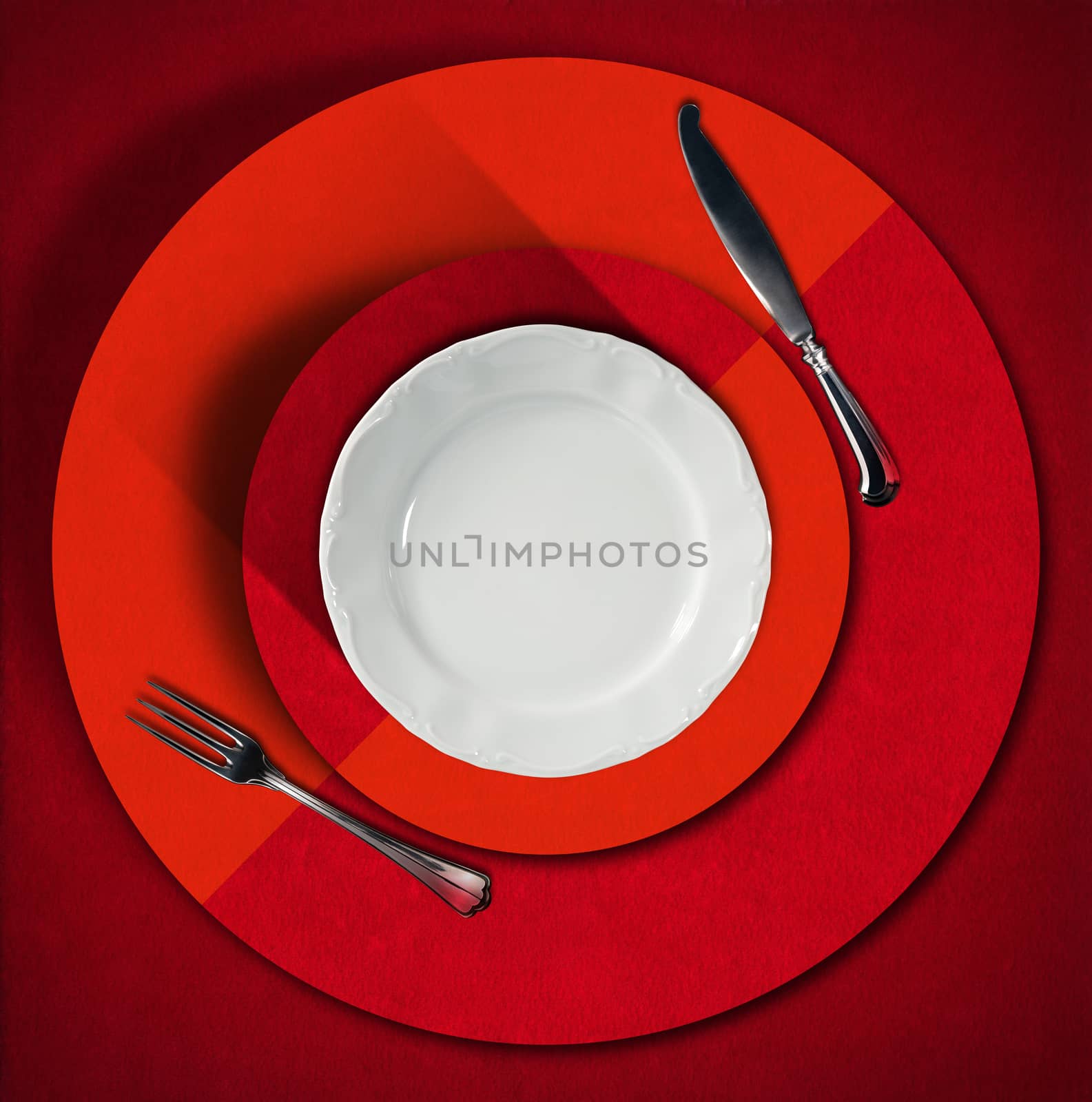Restaurant menu with empty white plate with silver cutlery, fork and knife, on red and orange velvet background with concentric circles and shadows