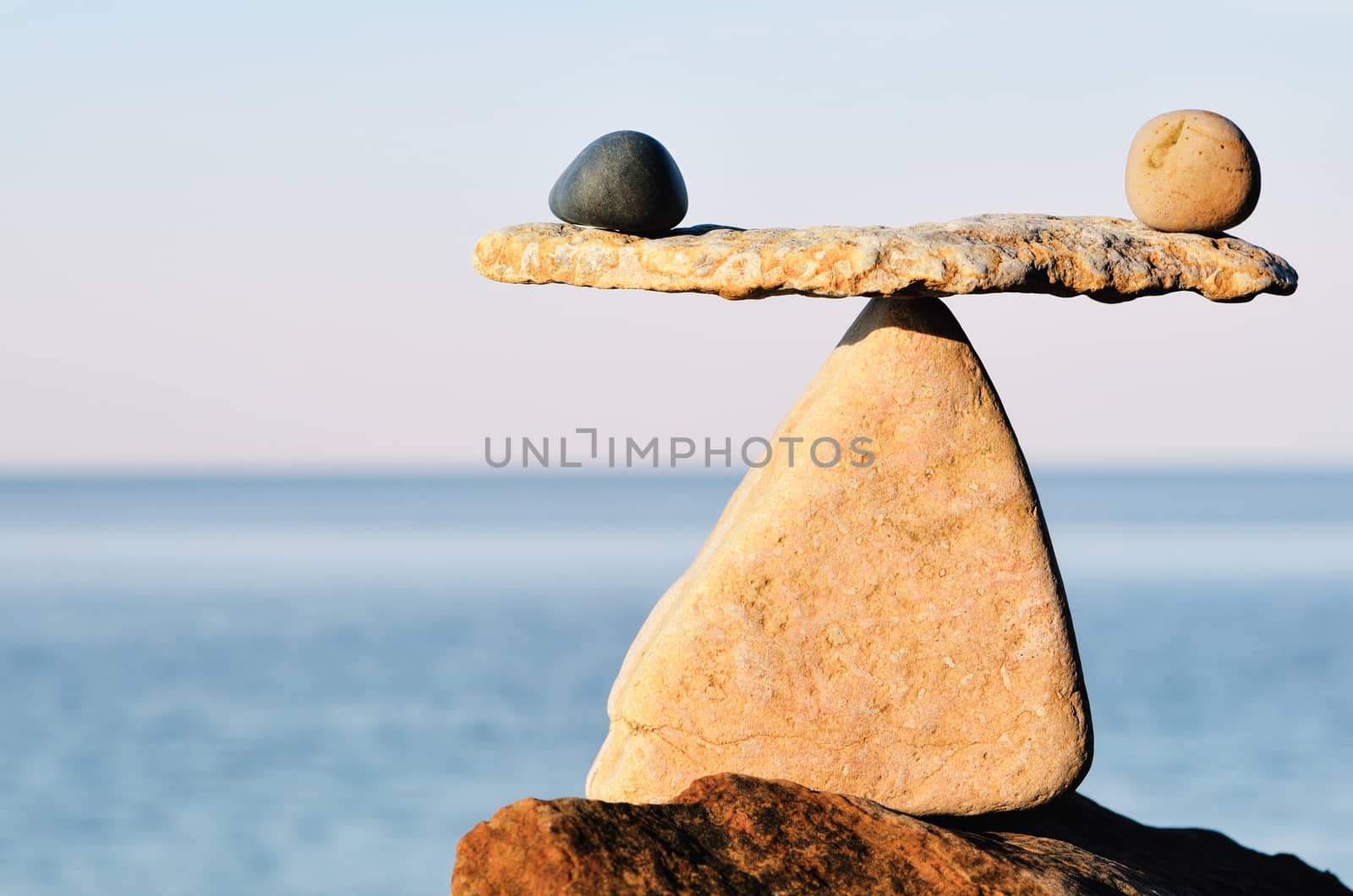 Symbol of scales is made of pebbles on the sea boulder