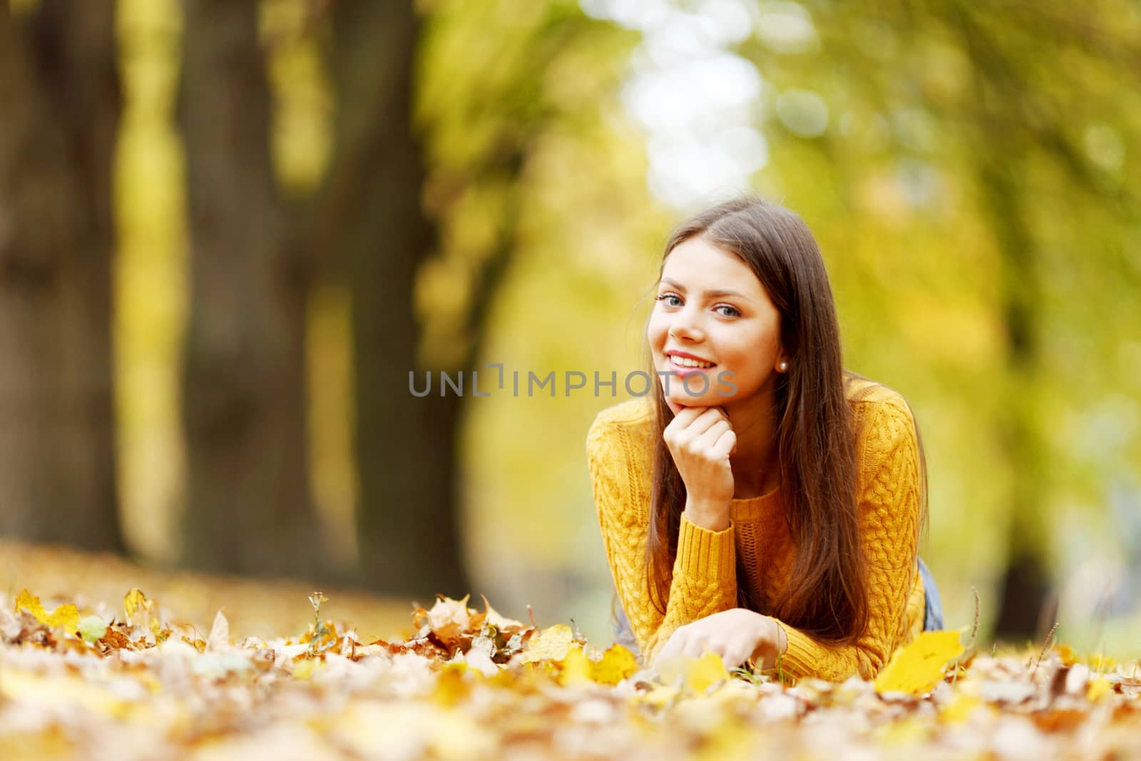 Cute woman laying in autumn park by Yellowj