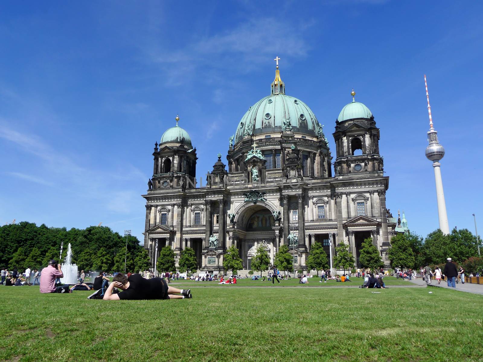 Tourists relaxing at Berlin Cathedral, the mother church during a beautiful sunny day with blue sky in summer, Germany, Europe.