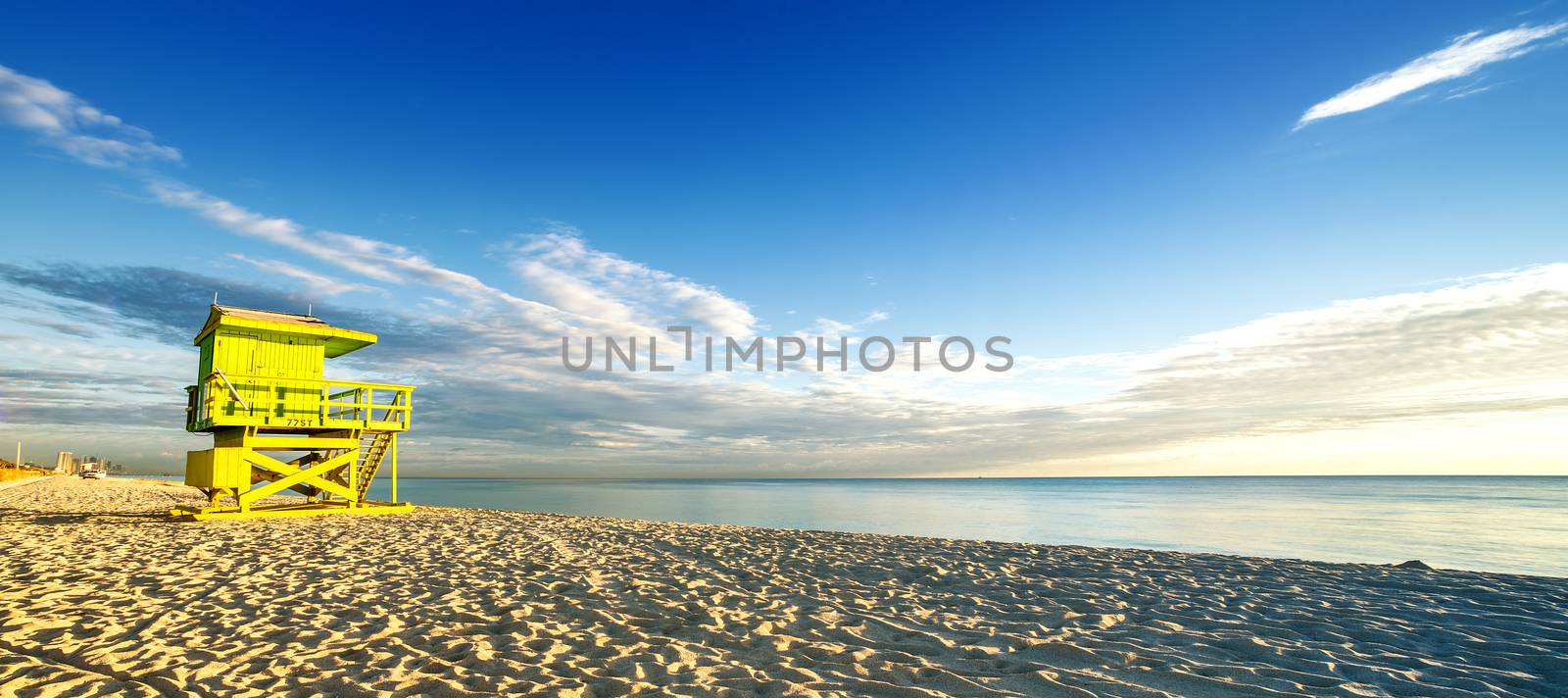 Miami South Beach sunrise with lifeguard tower and coastline with colorful cloud and blue sky. 