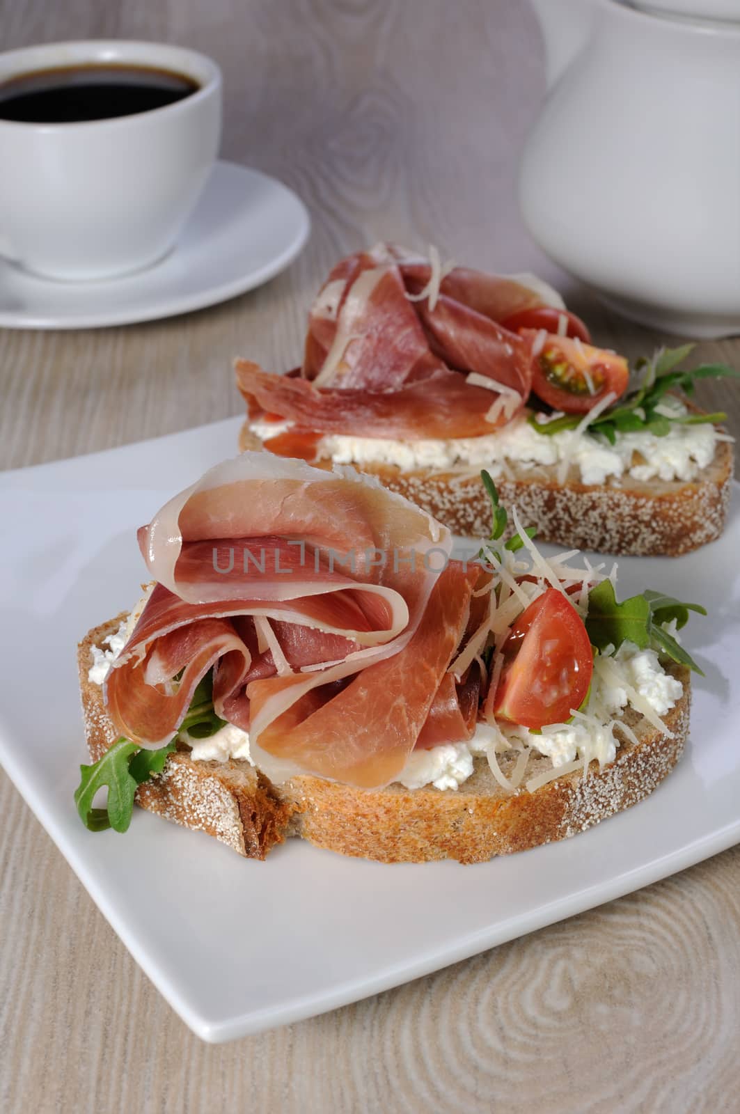 Sandwich of jamon with ricotta, arugula, cheese and a slice of cherry