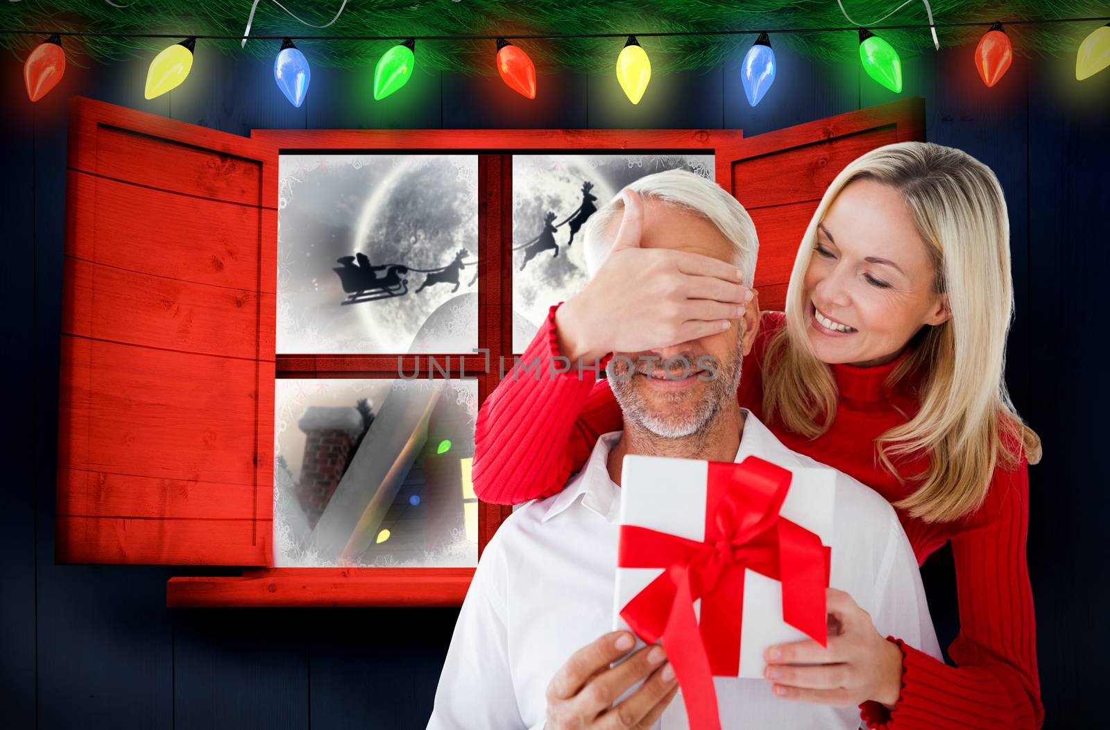 Composite image of loving couple with gift by Wavebreakmedia
