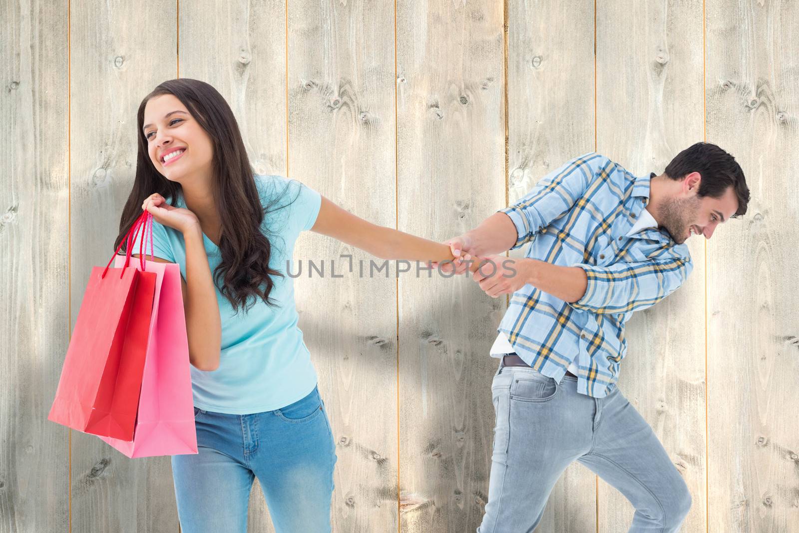 Happy couple with shopping bag against pale wooden planks