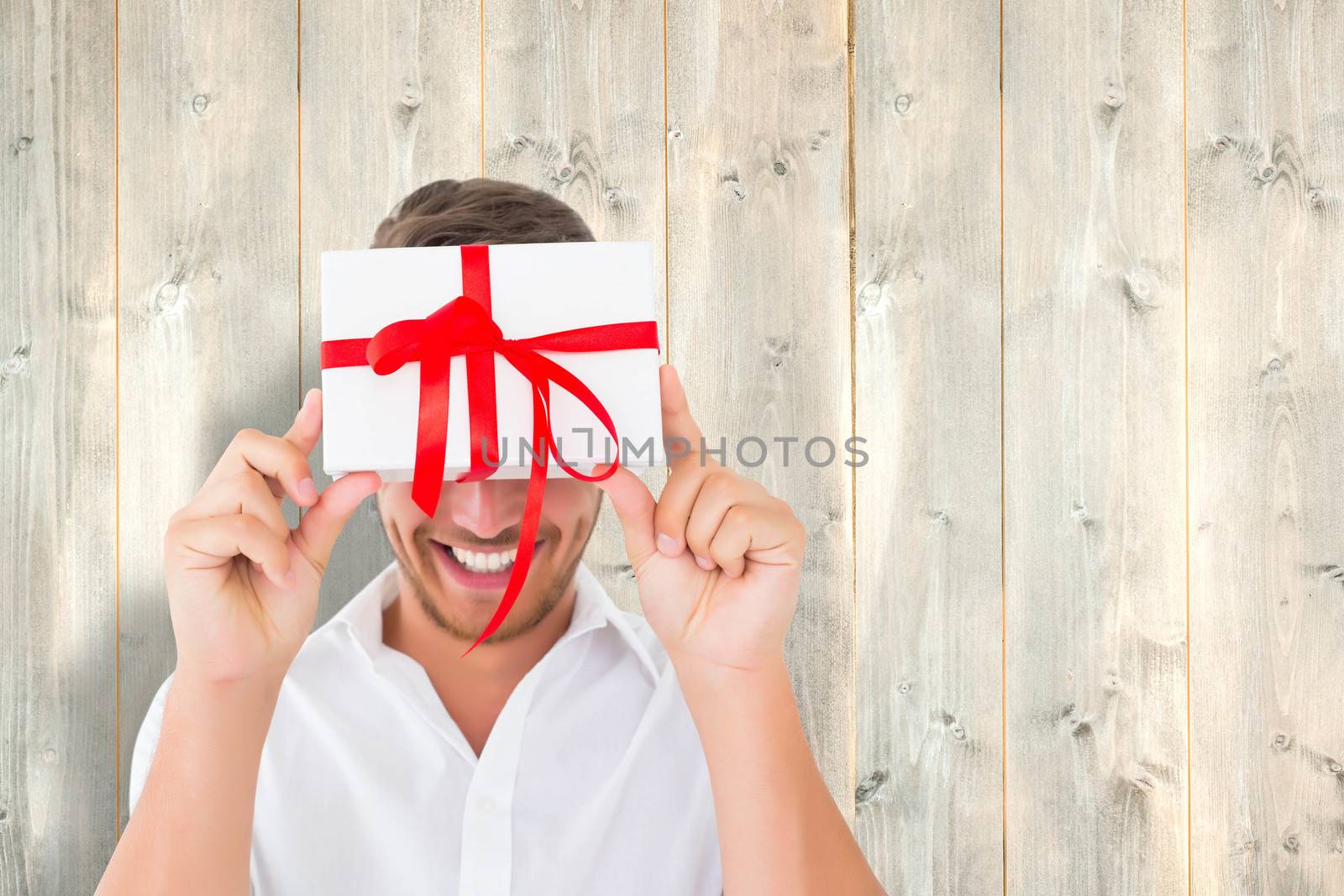 Man holding gift against pale wooden planks