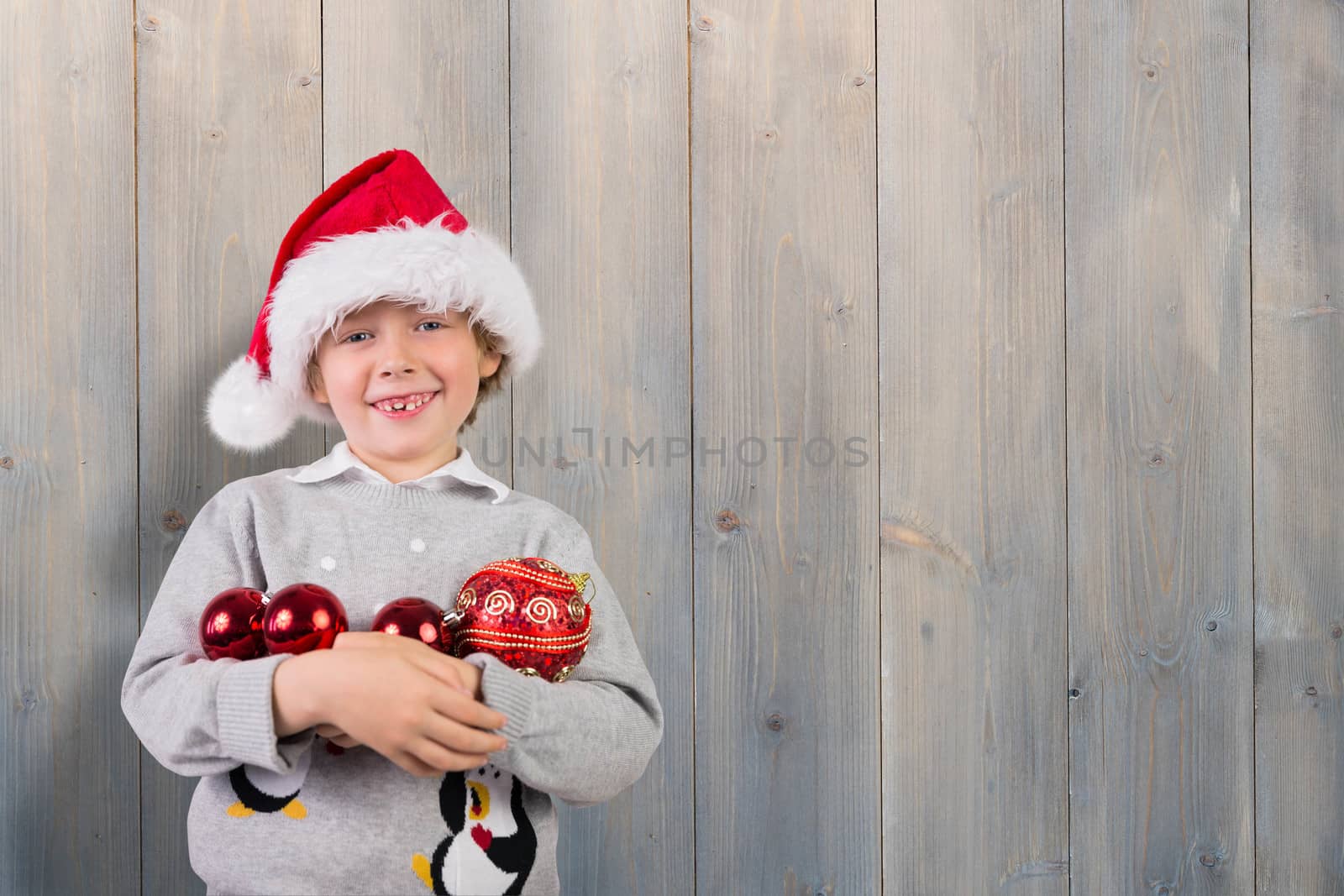 Festive boy smiling against pale grey wooden planks