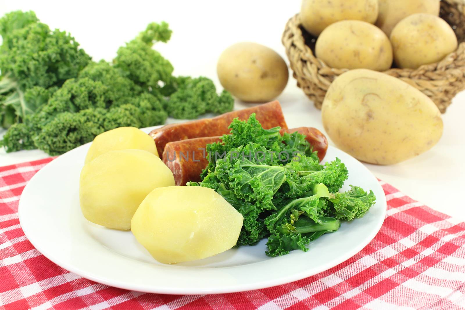 a white plate with kale and pee sausage