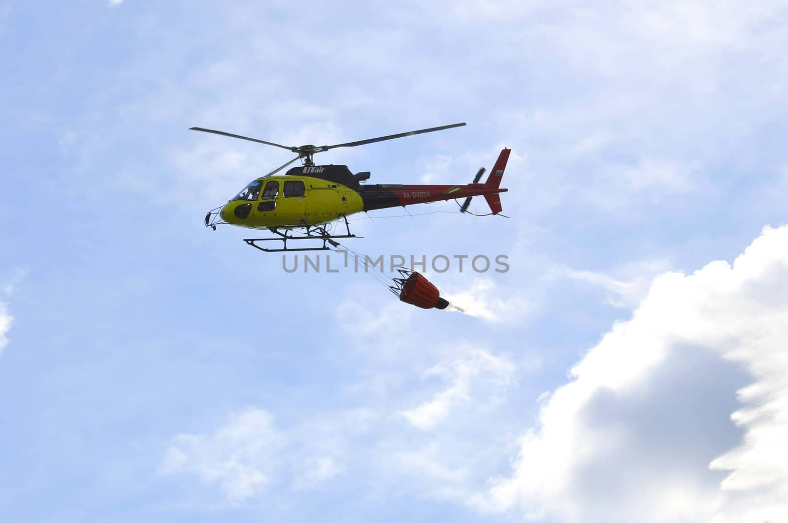 The small yellow helicopter of Utair airline in the sky