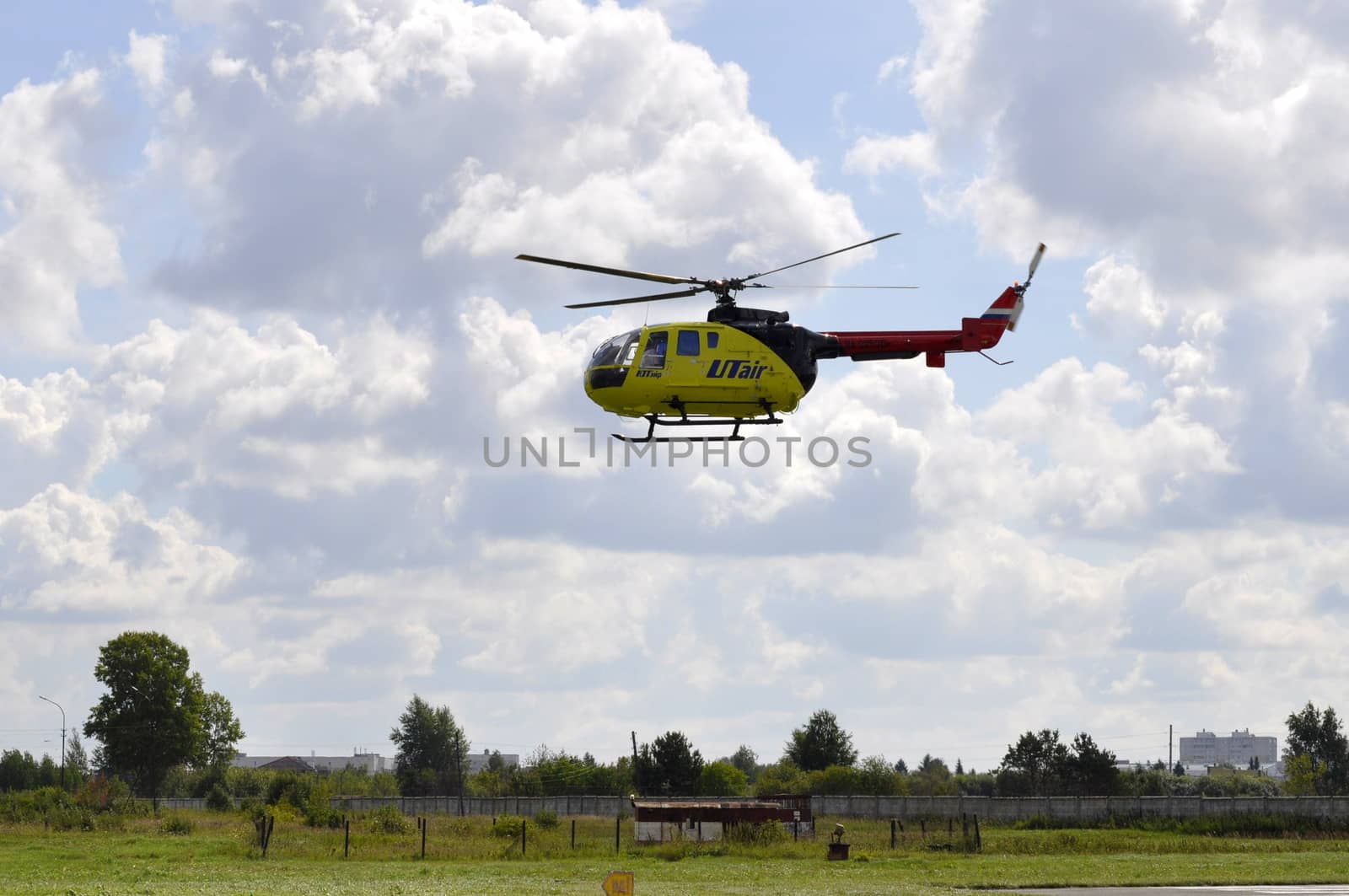 The small yellow helicopter of Utair airline in the sky. by veronka72