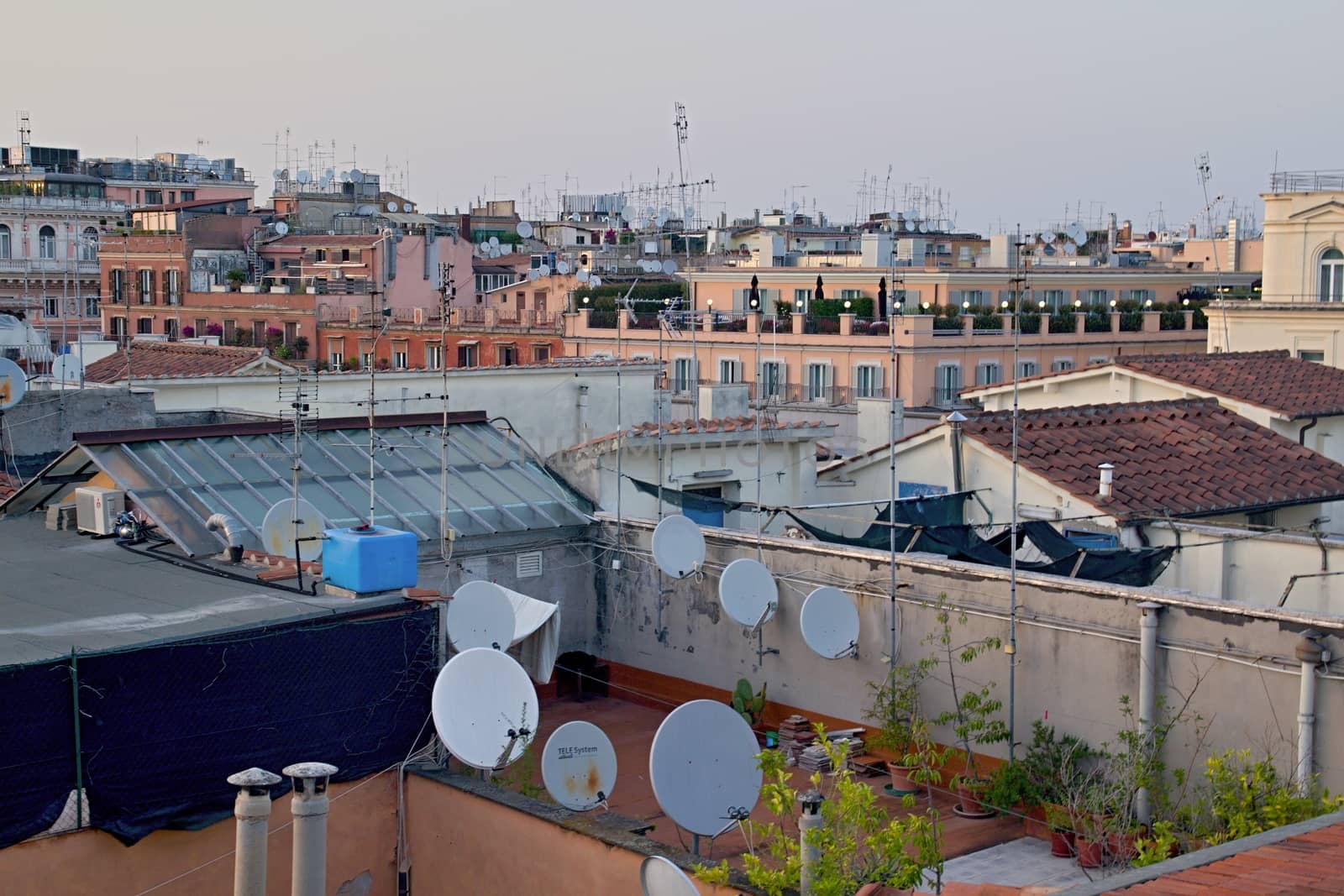 Photo shows Rome cityscape with houses and roofs.