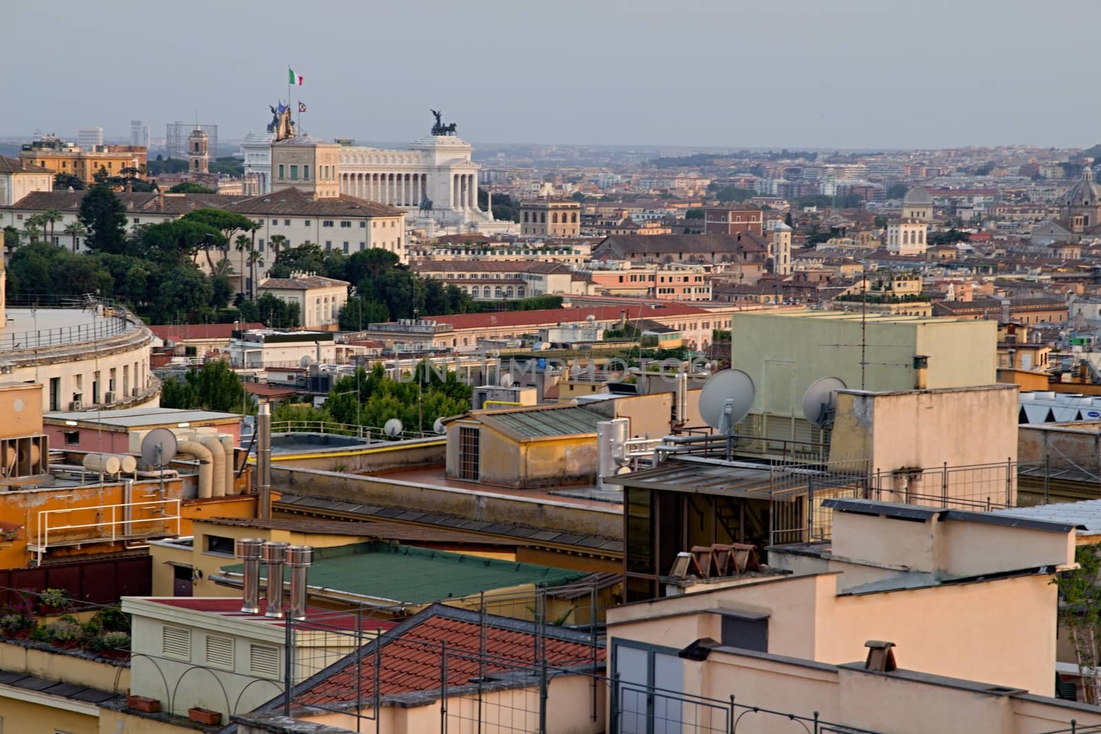 Photo shows Rome cityscape with houses and roofs.