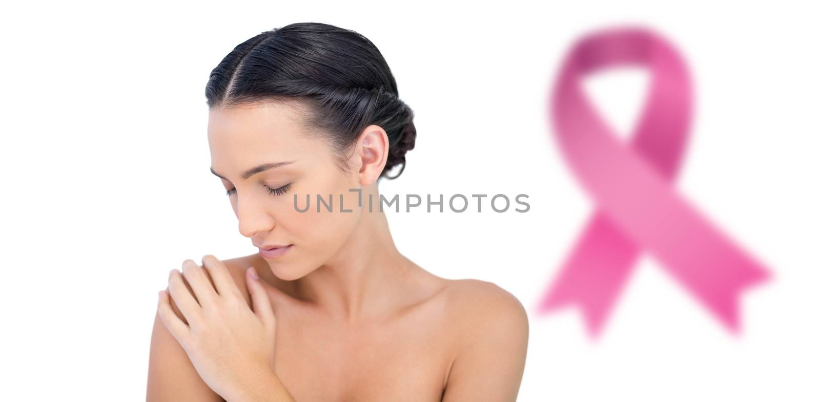 Natural model posing eyes closed against breast cancer awareness ribbon