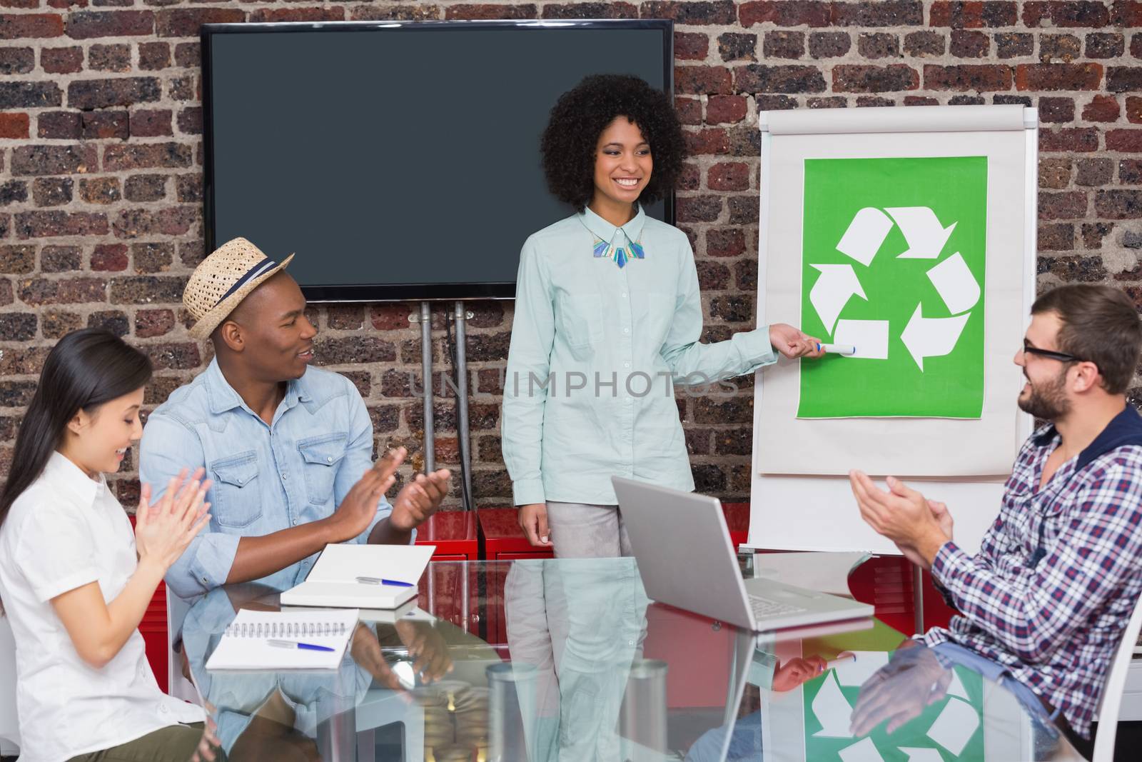 Creative business team in meeting with recycling symbol on whiteboard