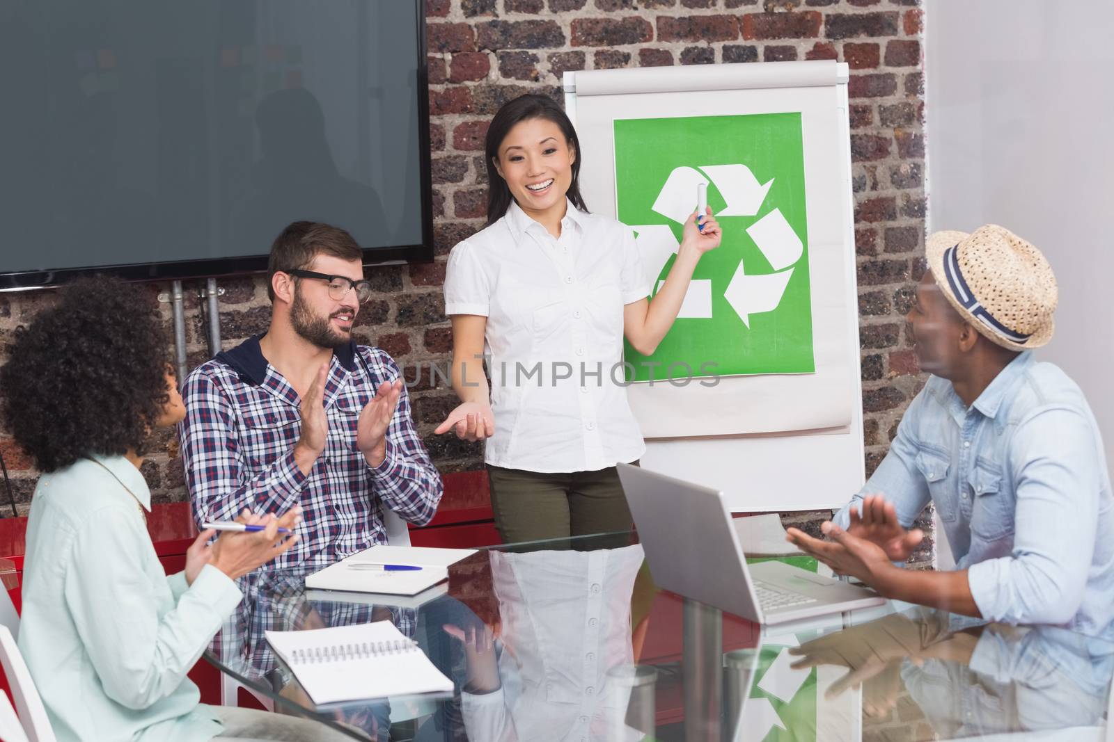 Creative business team in meeting with recycling symbol on whiteboard