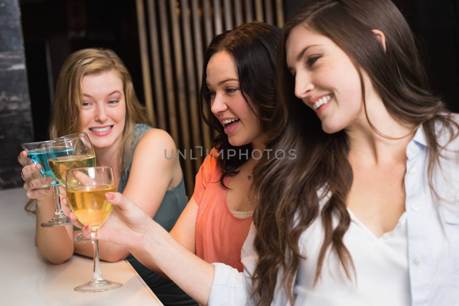 Pretty friends meeting up for a drink at the bar