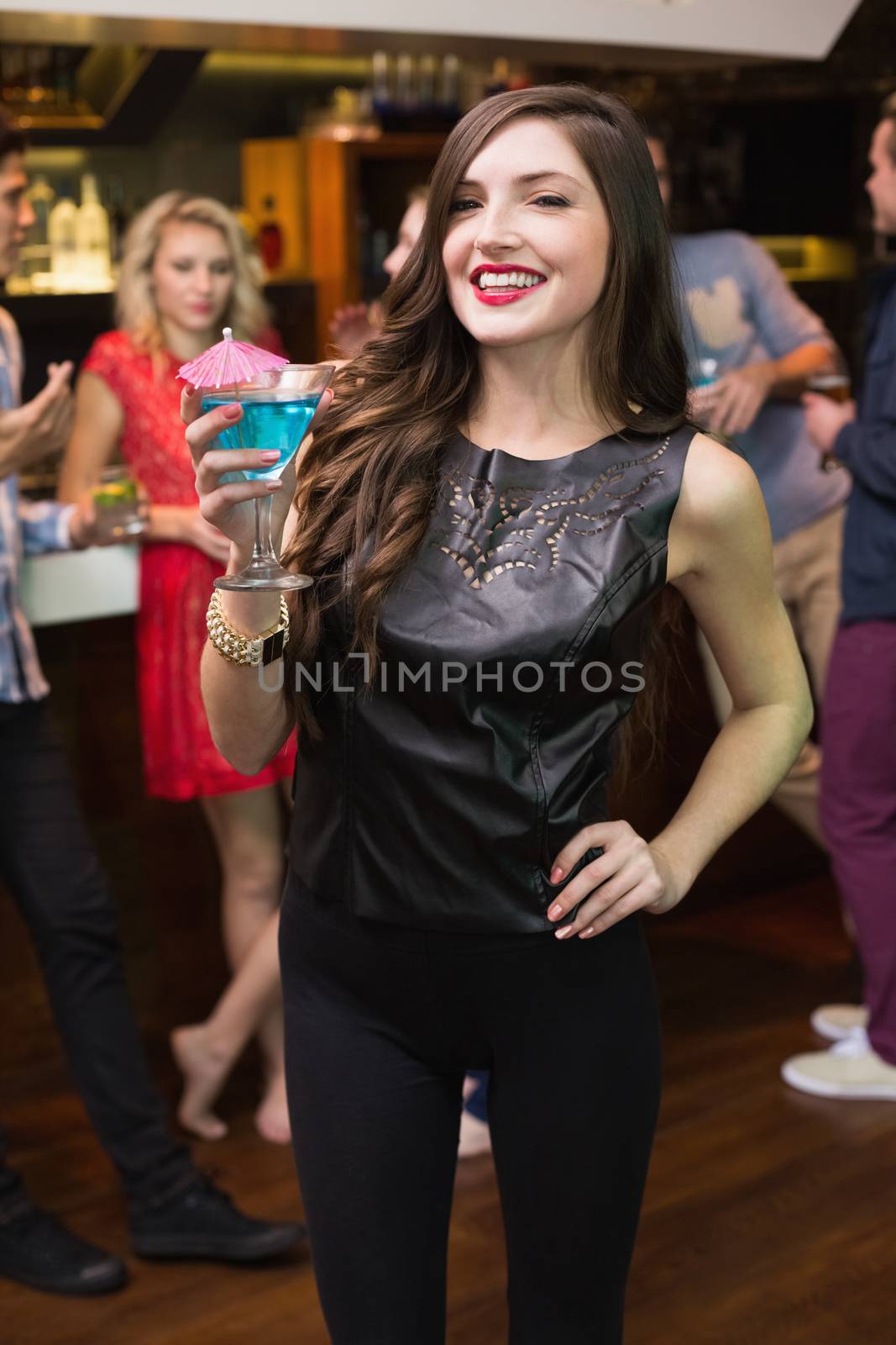 Pretty brunette drinking a cocktail at the bar