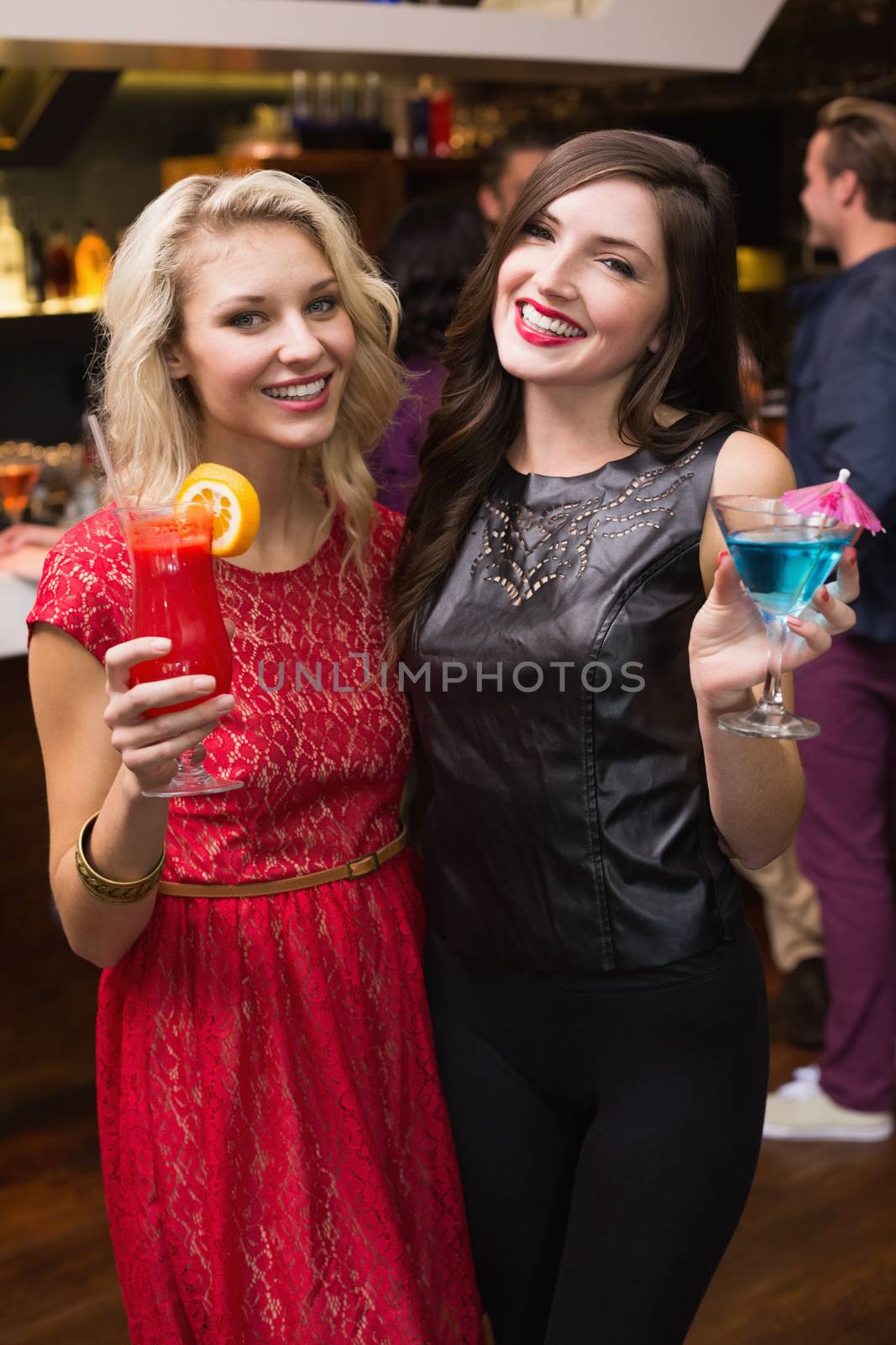Pretty friends drinking a cocktail by Wavebreakmedia