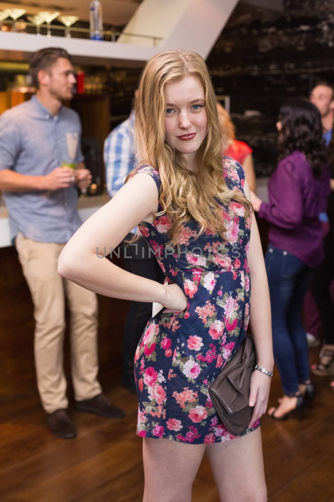 Pretty blonde smiling at camera at the bar