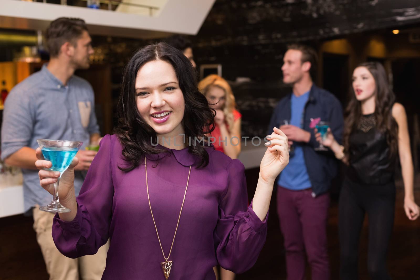 Pretty brunette drinking a cocktail at the bar