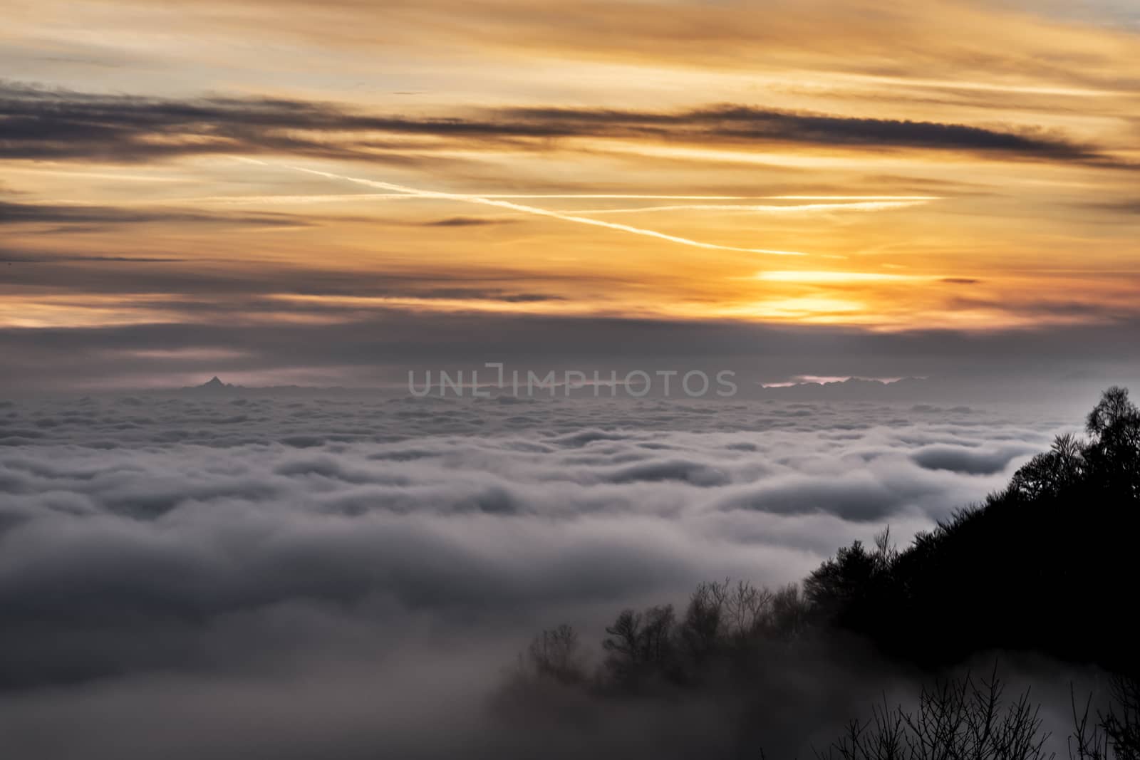 sea of clouds at sundown and mountain Monviso on the horizon