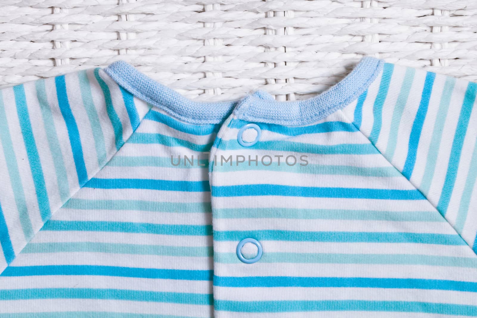Part of a stripey blue and white cotton baby top