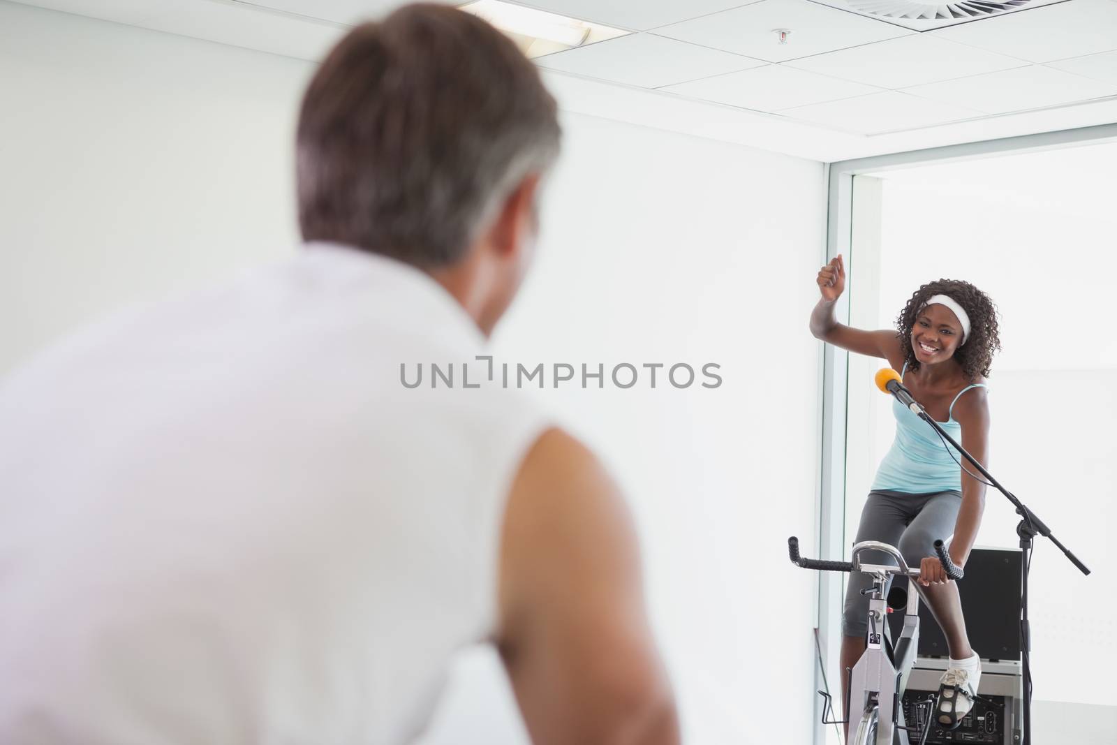 Spinning instructor motivating her class at the gym