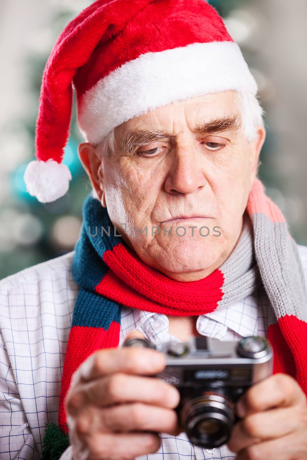 Senior man taking photo against Christmas background