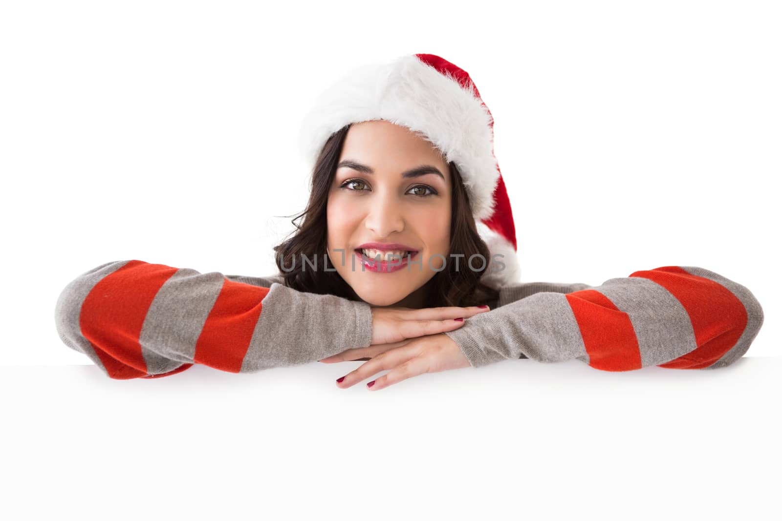 Beauty brunette in santa hat smiling at camera on white background