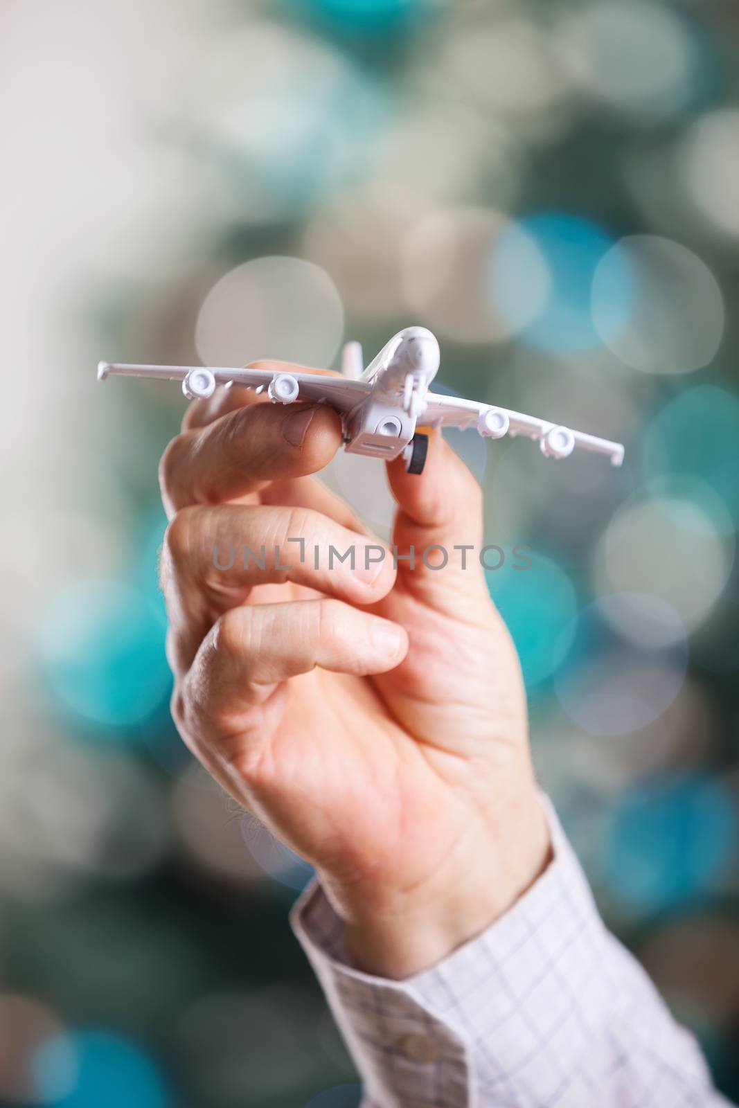Closeup of man hand holding model of airplane by photobac