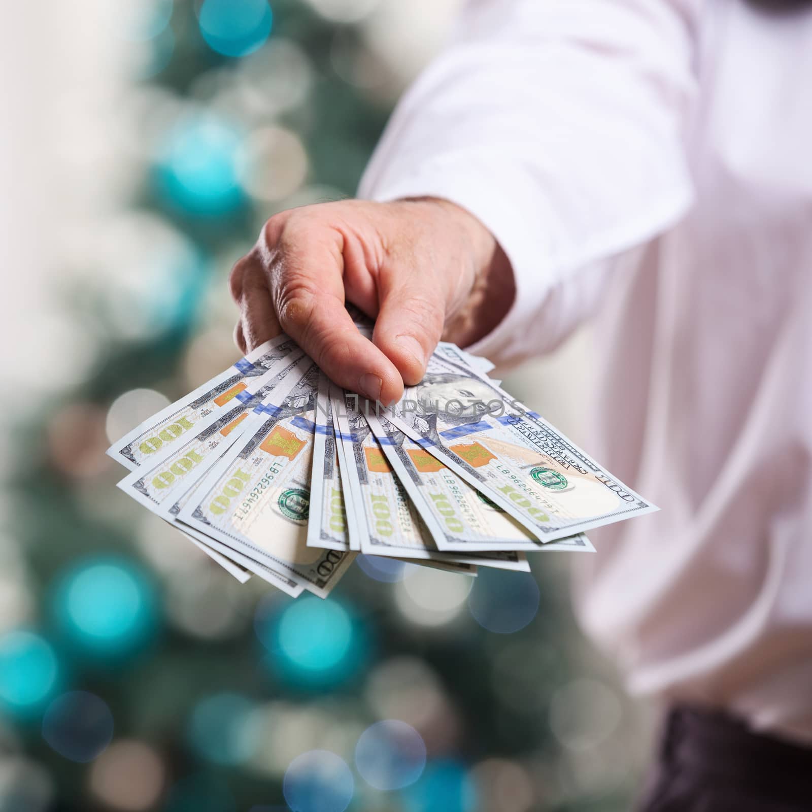 Male hand with money on a Christmas background