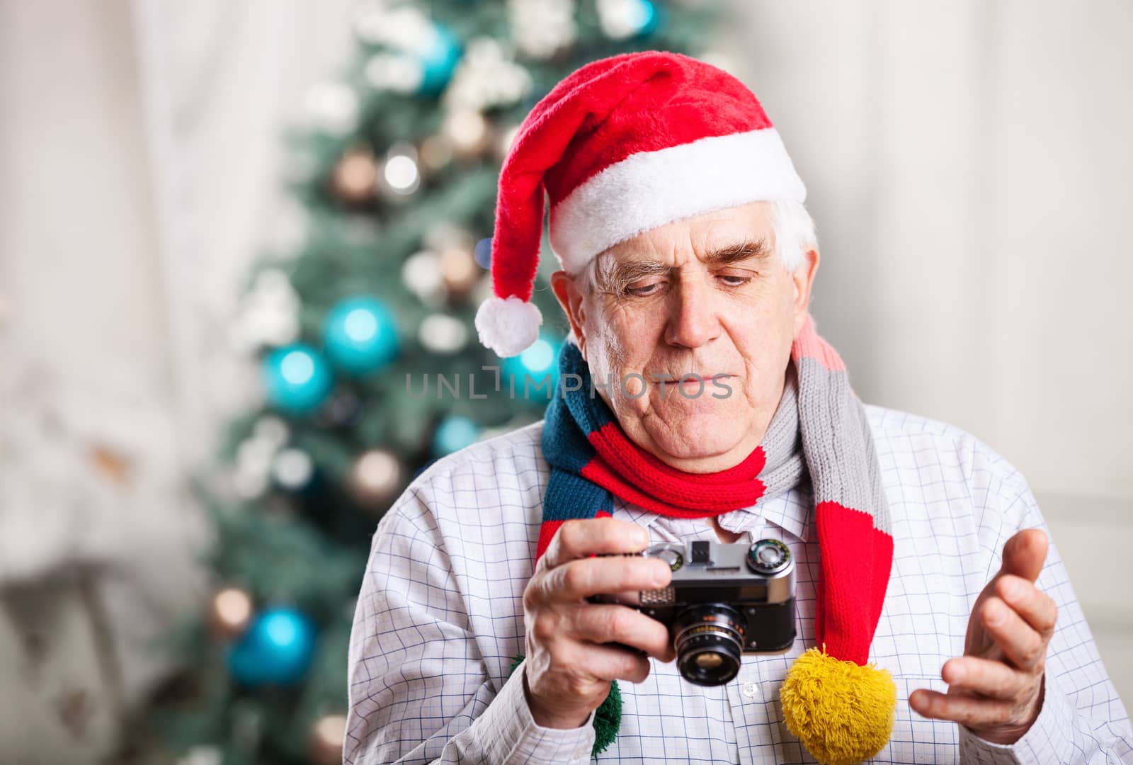 Senior man taking photo against Christmas background