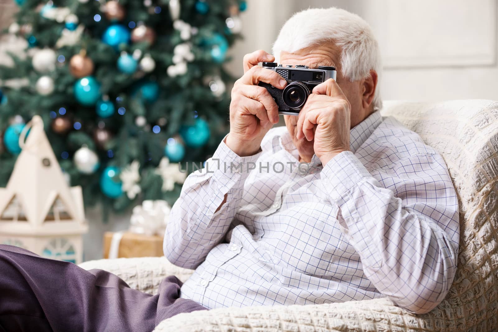 Senior man taking photo over Christmas background