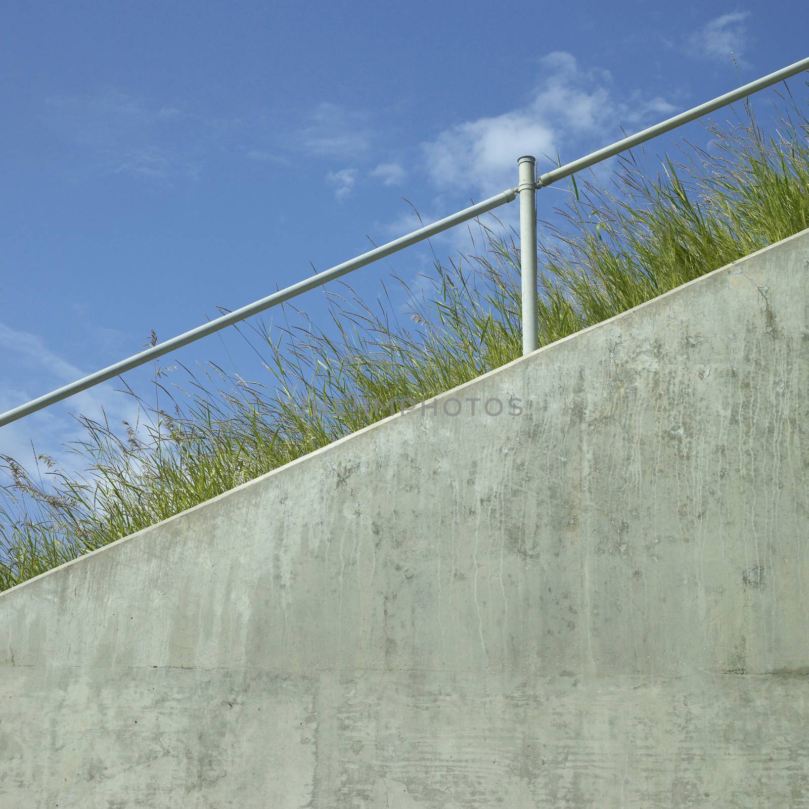 Industrial hand rail with grass and blue sky