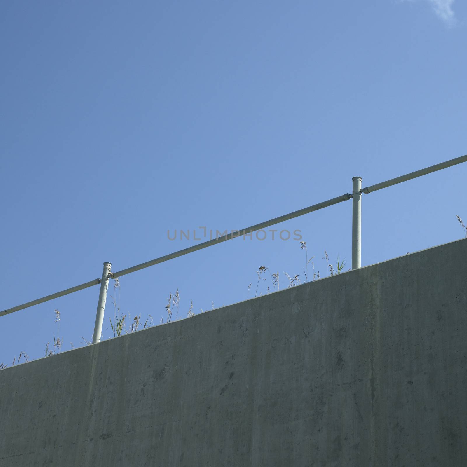 Industrial hand rail with grass and blue sky