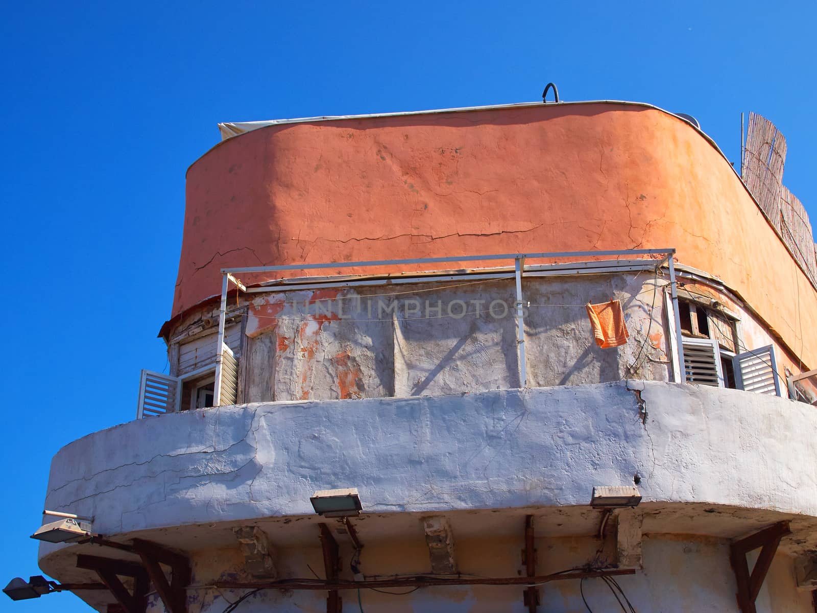 Deteriorated old house painted in color with clear blue sky background