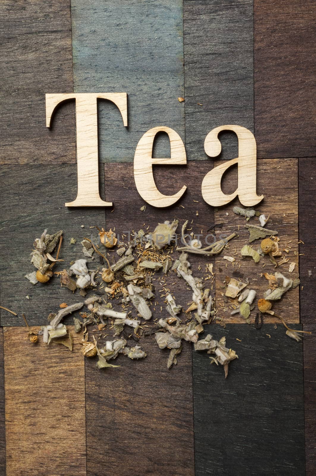 Tea time words and dry mountain tea leaves on wooden background