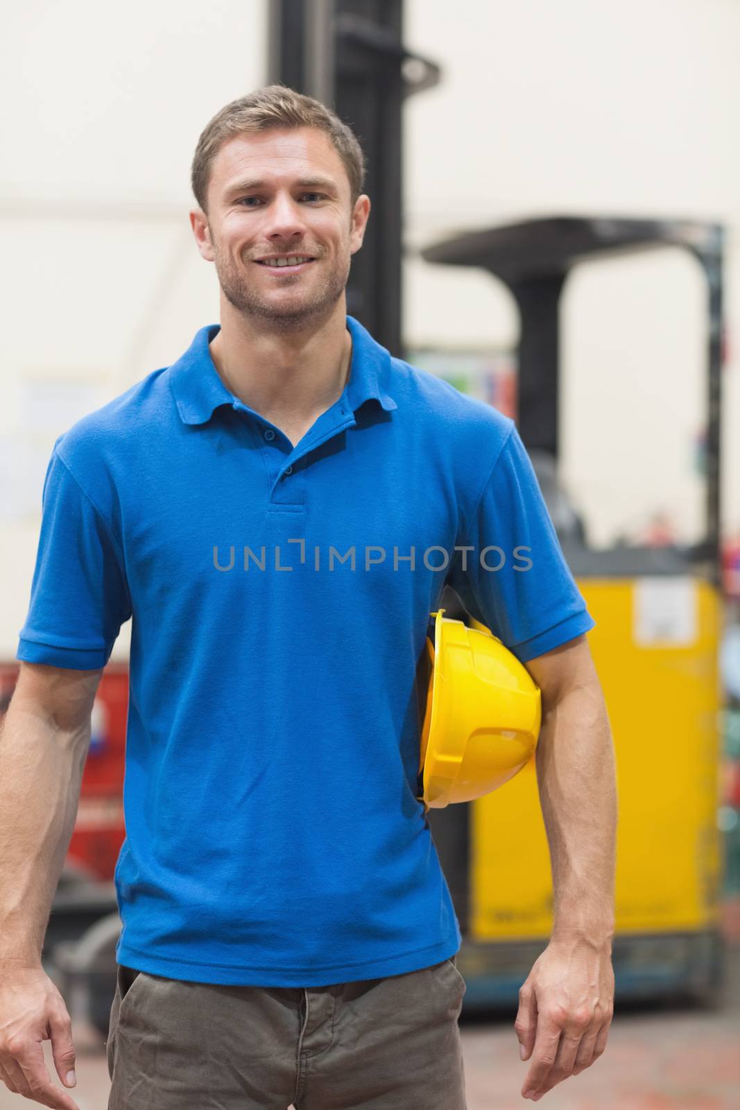 Handsome warehouse worker smiling at camera by Wavebreakmedia