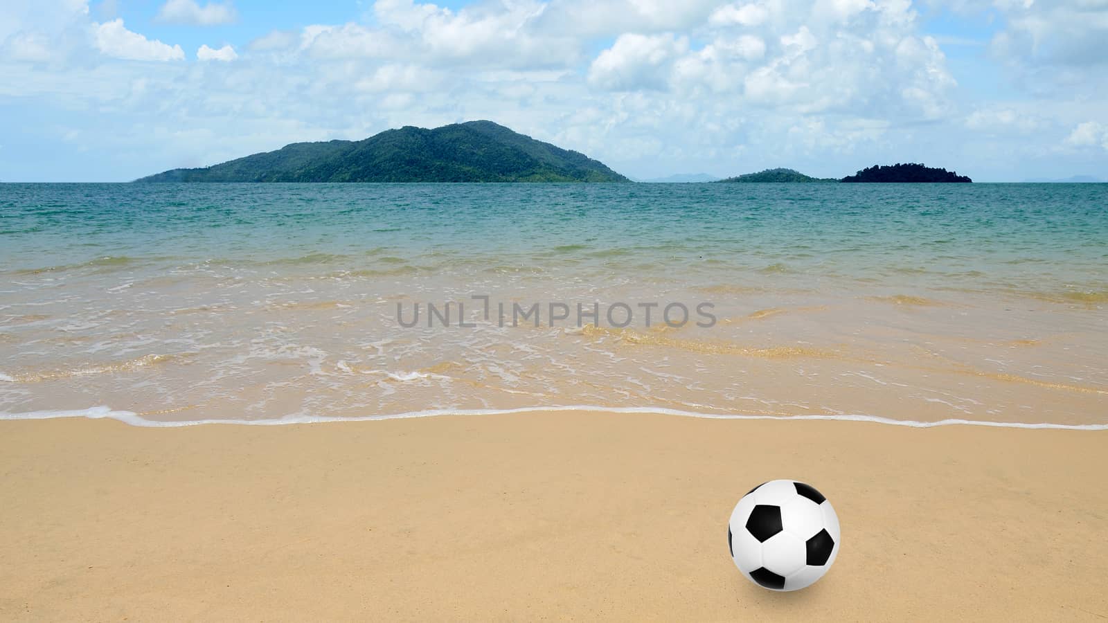 Football at the beach with island background by pixbox77