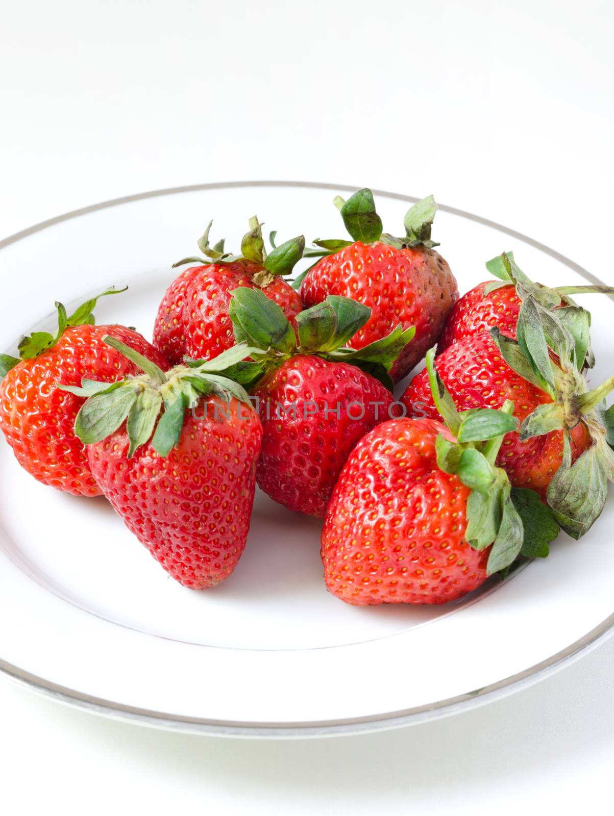 Strawberries in a plate on white by siraanamwong